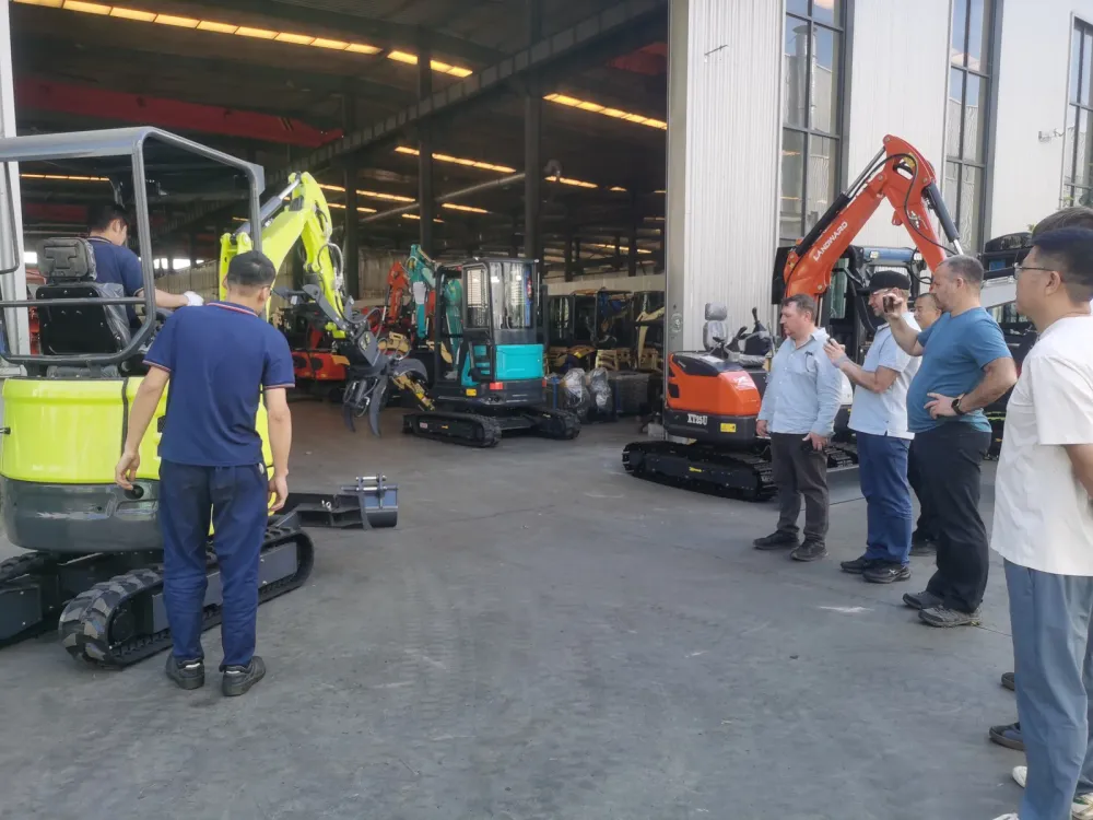 Mini excavators and other compact machines standing on the workshop floor during a customer visit