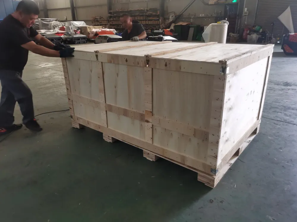 Worker securing the plywood crate lid on a packed remote control mower